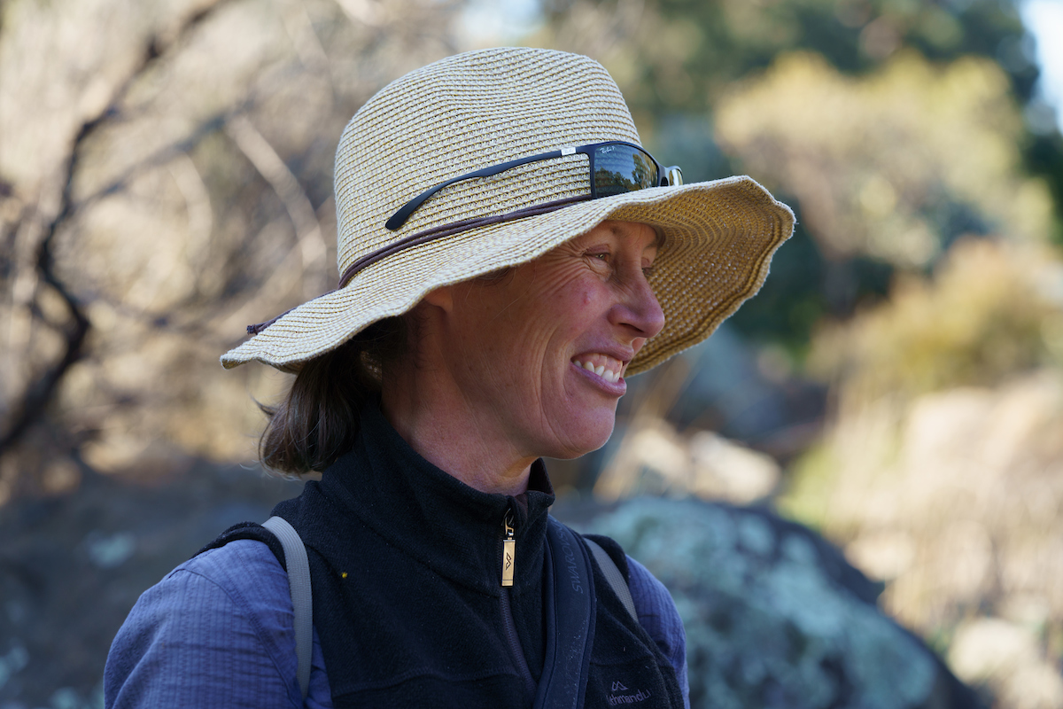 Woman in a hat outdoors smiling