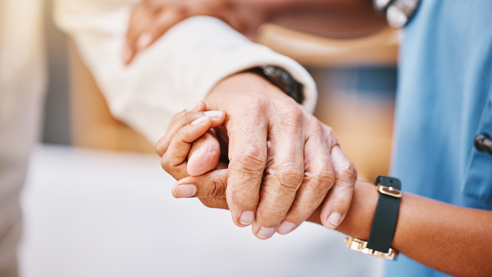 Nurse holding the hand of an older patient