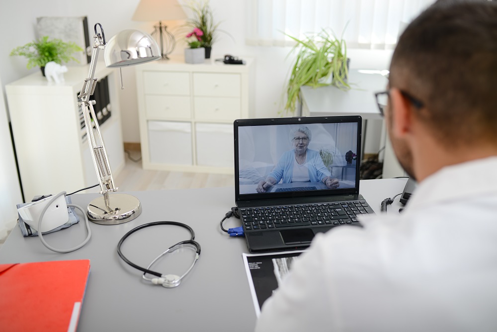 Man at computer talking to patient via video call