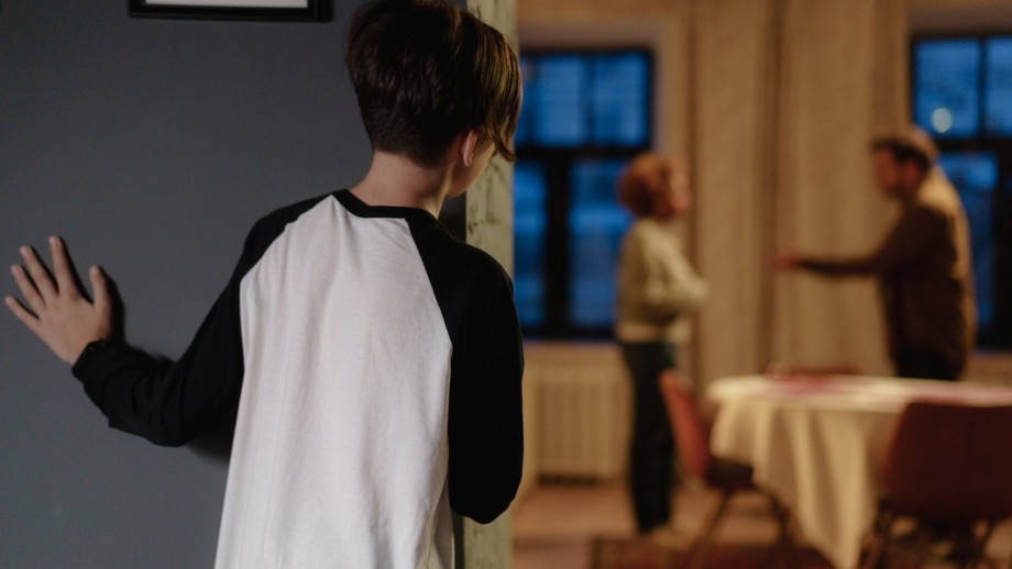 boy watching on as parents appear to argue