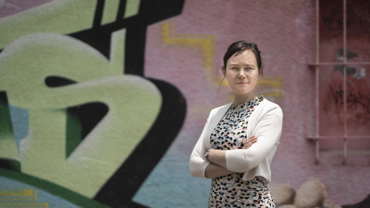 Dr Anna Olsen in front of graffiti wall