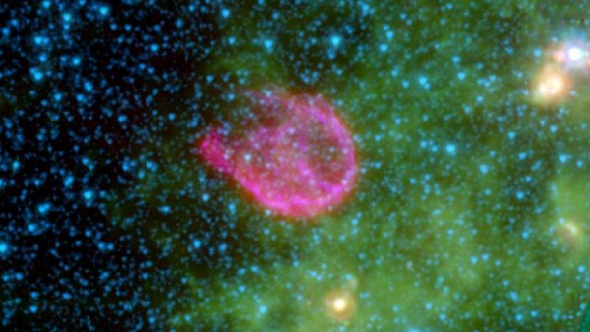 A false-colour composite of the remnant of N132D. Shows stars on blue, black, green and pink background.