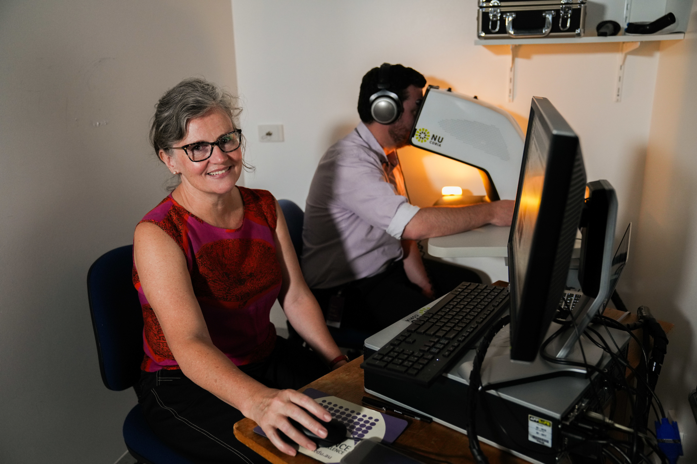 Sarah Mann is studying the effects of music on the human body by seeing how a person's pupil responds to different sounds. Photo: Tracey Nearmy/ANU Sarah Mann sits at her computer while a student completes her pupilometry study.