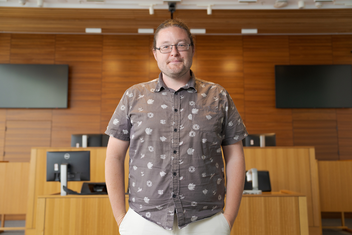 Dr Brad Tucker at the ANU College of Law Moot Court A smiling man in a brown patterned shirt standing in a court room