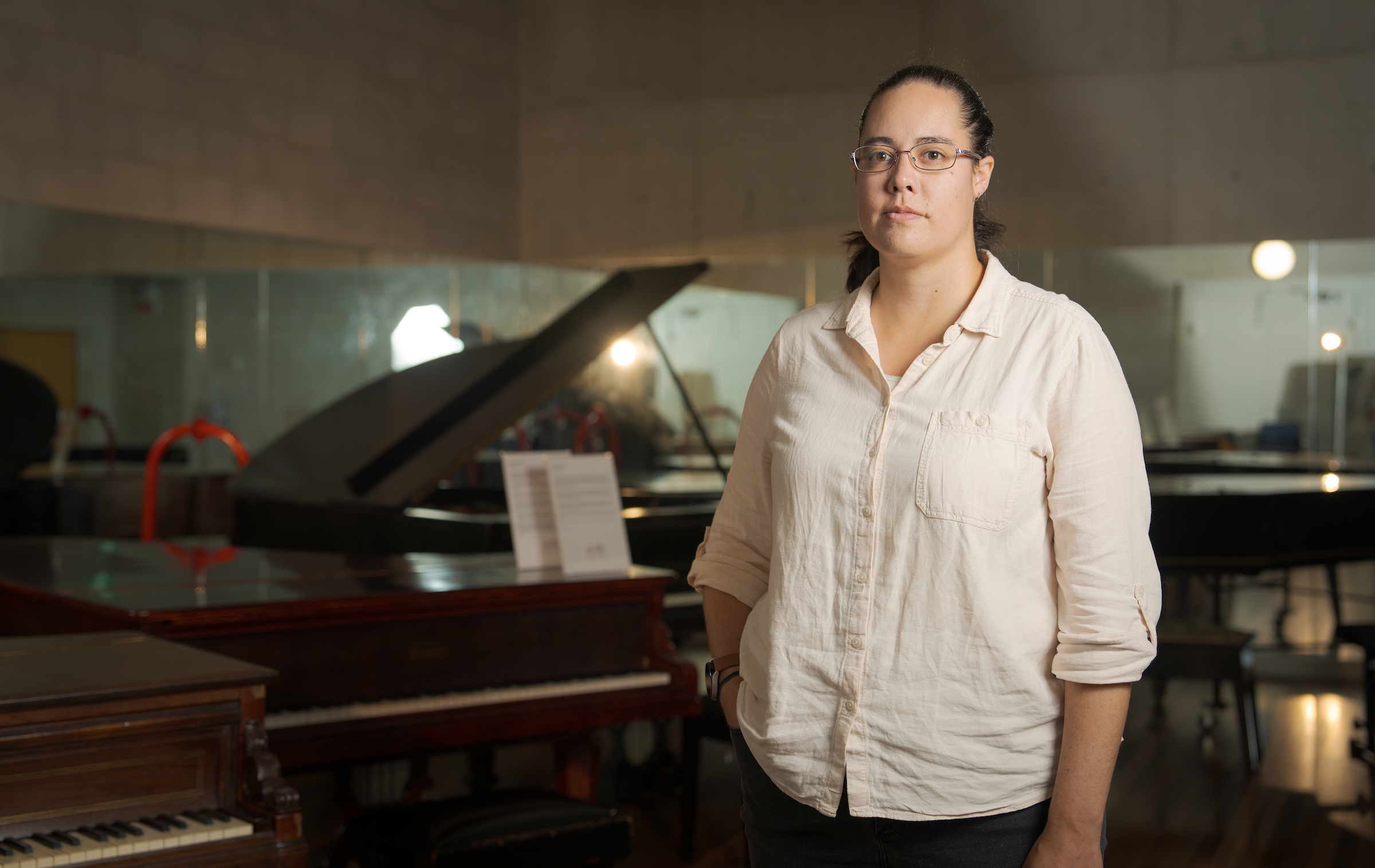 A woman standing next to a piano