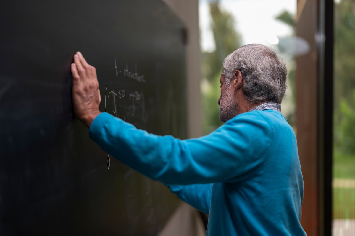 Photo: Jamie Kidston/ANU A man writing on a blackboard