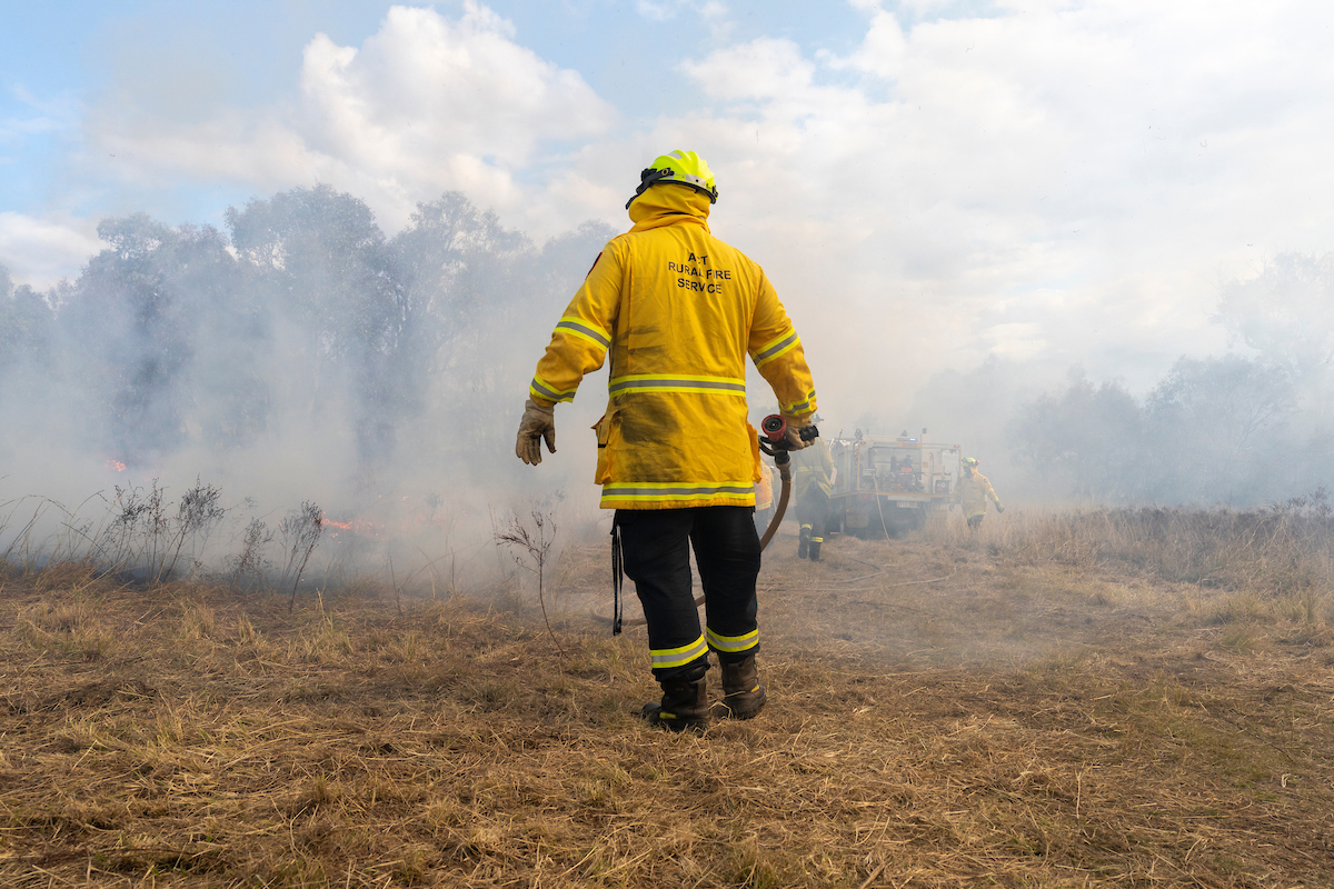 Controlled burn at a Bushfire Research Centre of Excellence field day. Photo: Jamie Kidston/ANU Firefighter in a dry field among smoke