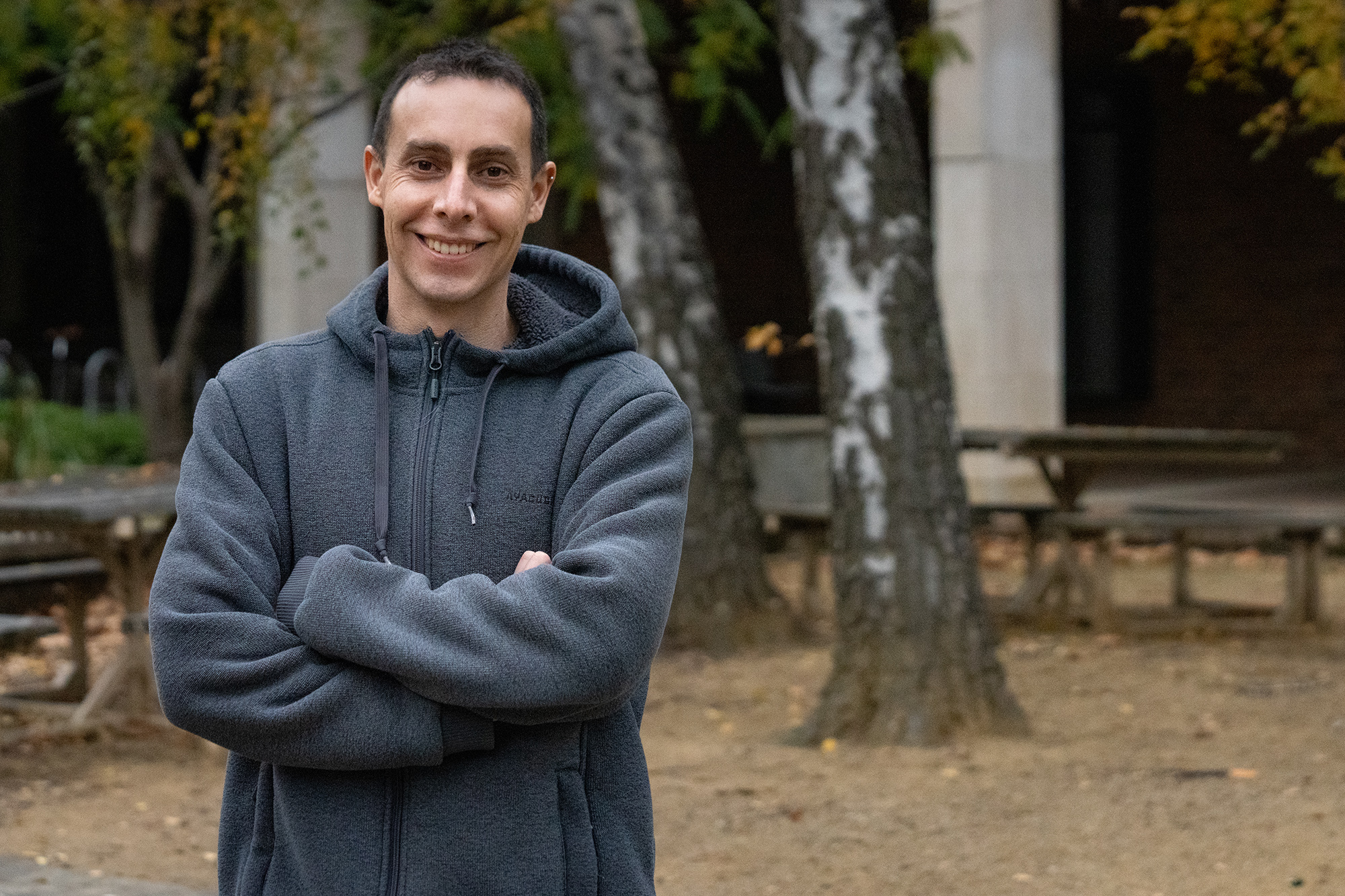 Dr Simon Haine. Photo: Nicholas Vevers/ANU. Man in a hooded jumper standing outside.