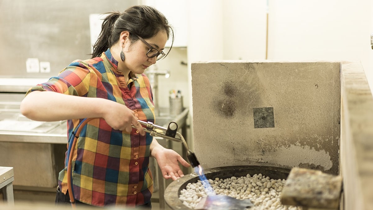Student using silversmithing equipment
