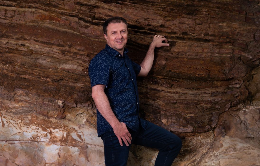 Man next to large rock