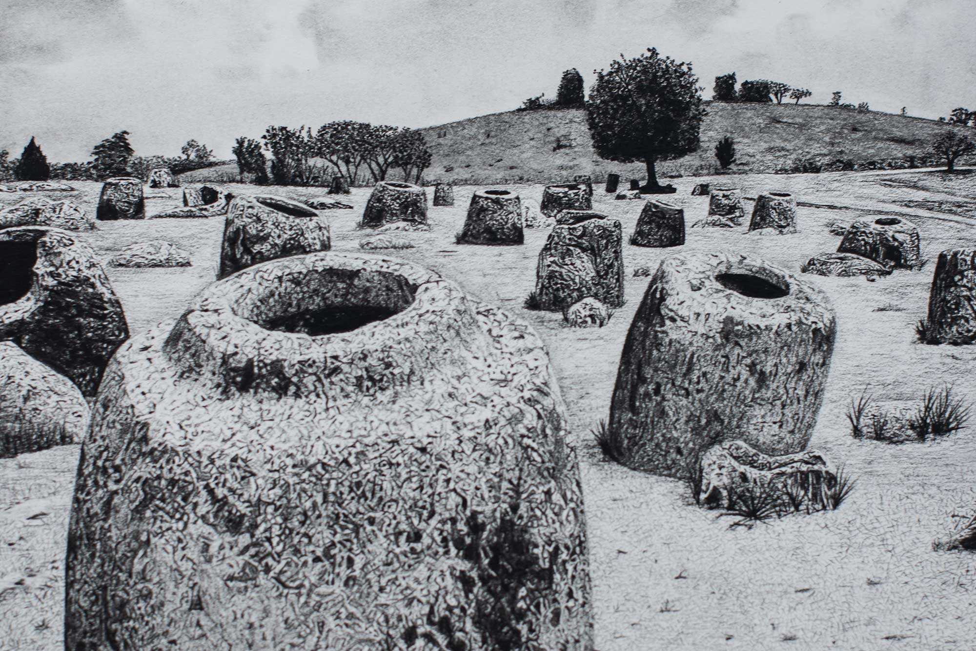 A black and white illustration of a landscape featuring numerous stone jars scattered across a grassy field, with trees and a hill in the background.