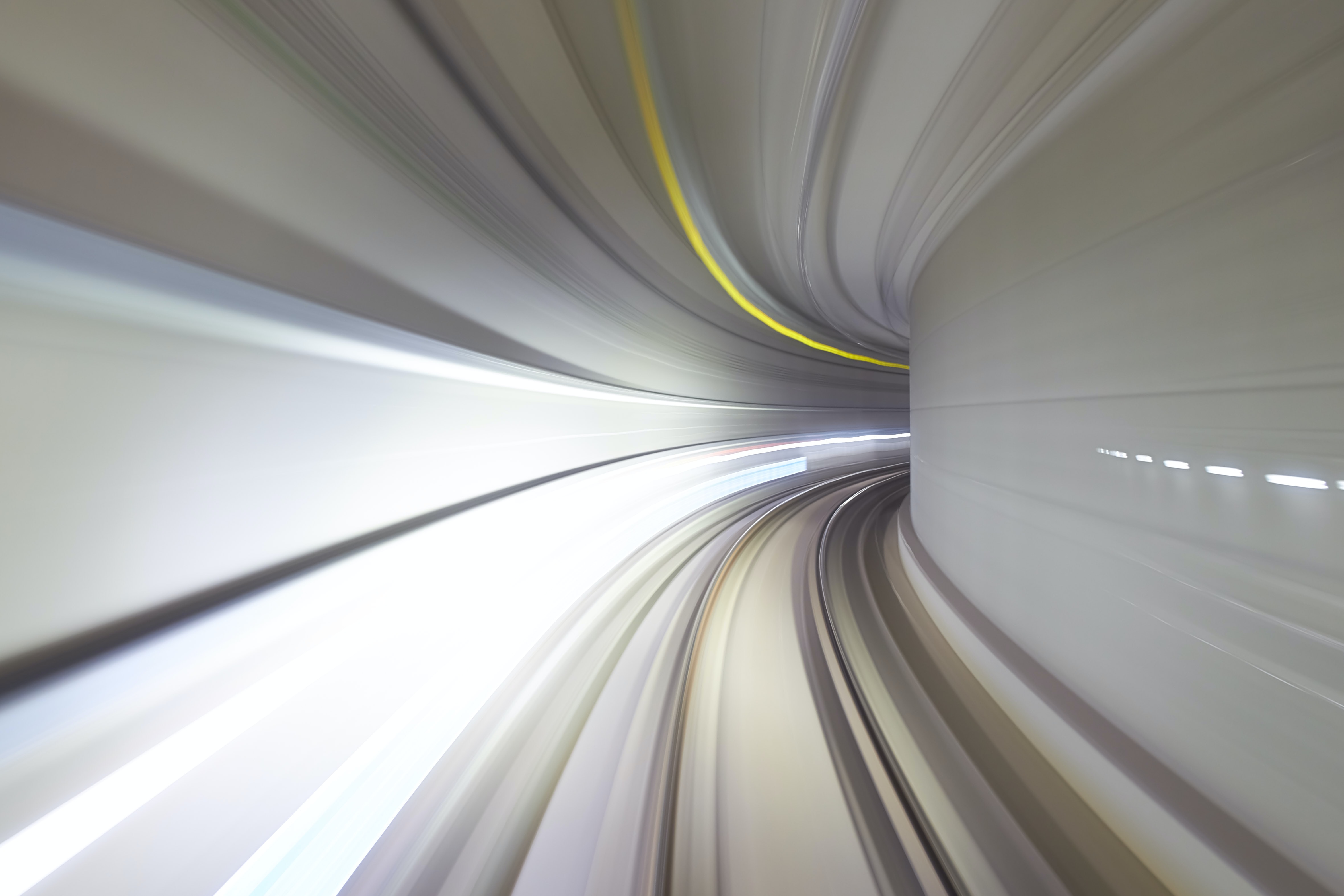 Blurred lines of a tunnel from the perspective of a fast-moving train, illustrating motion.
