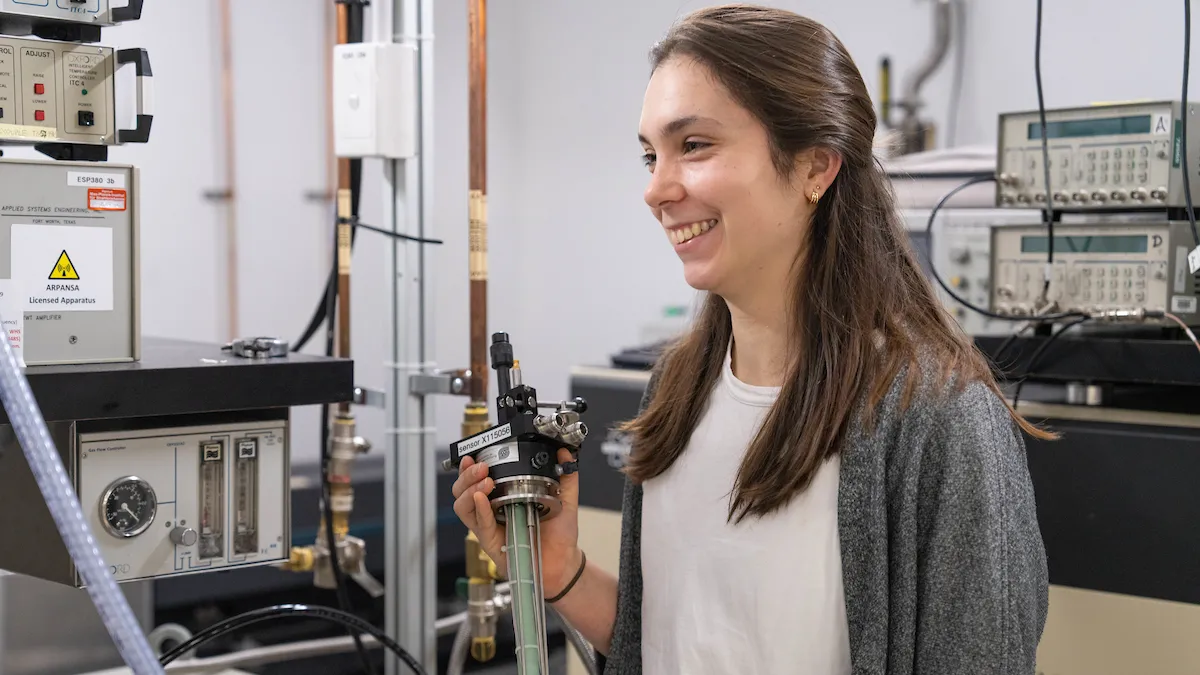 Dr Martyna Judd in a technical laboratory holding instrumentation