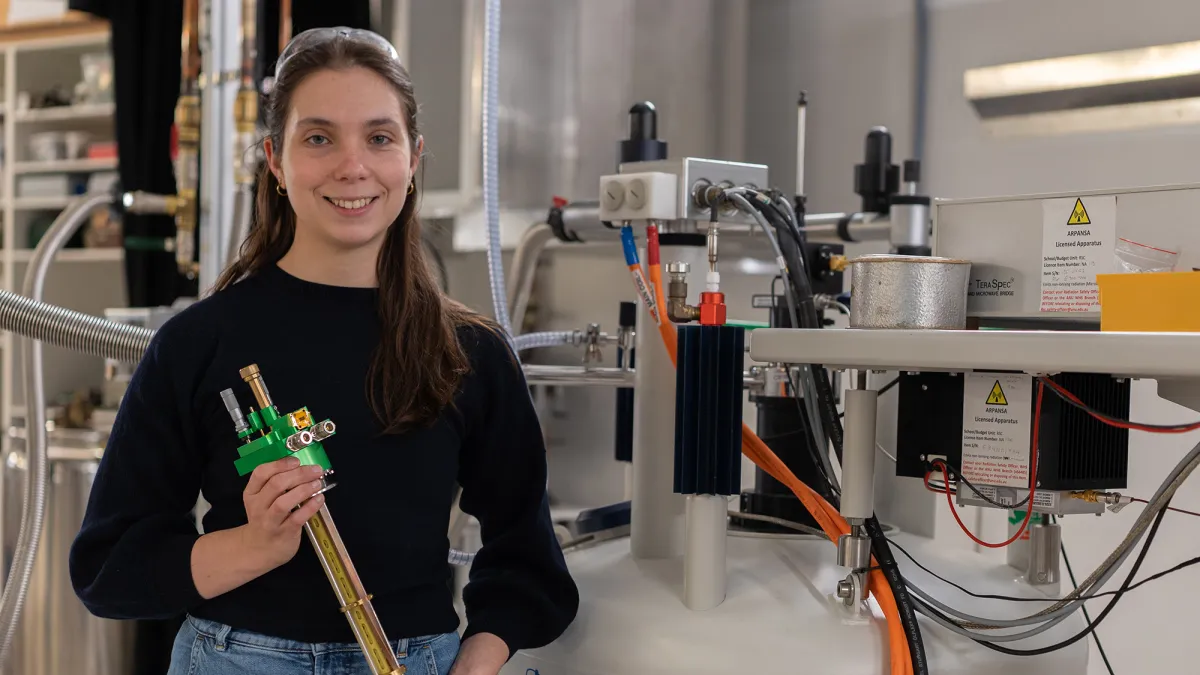 Dr Martyna Judd in a technical laboratory holding instrumentation