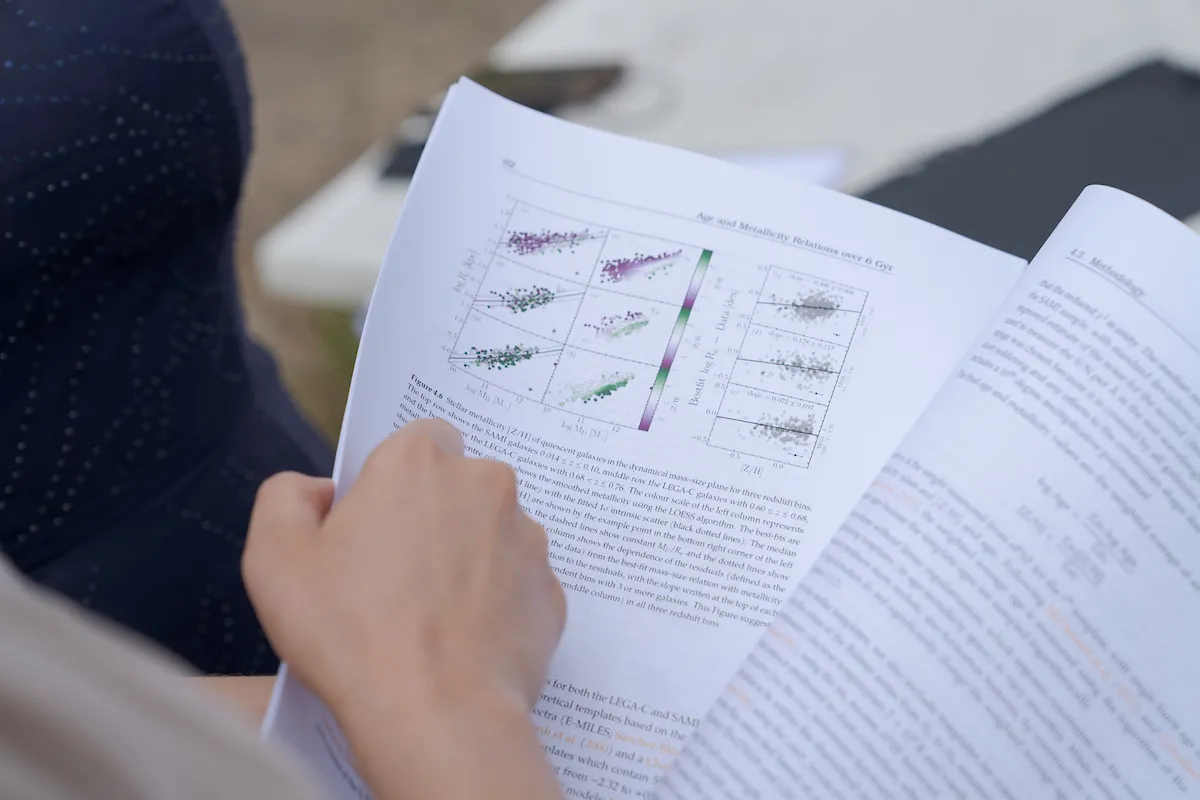 A hand flipping through pages of typed words and graphs