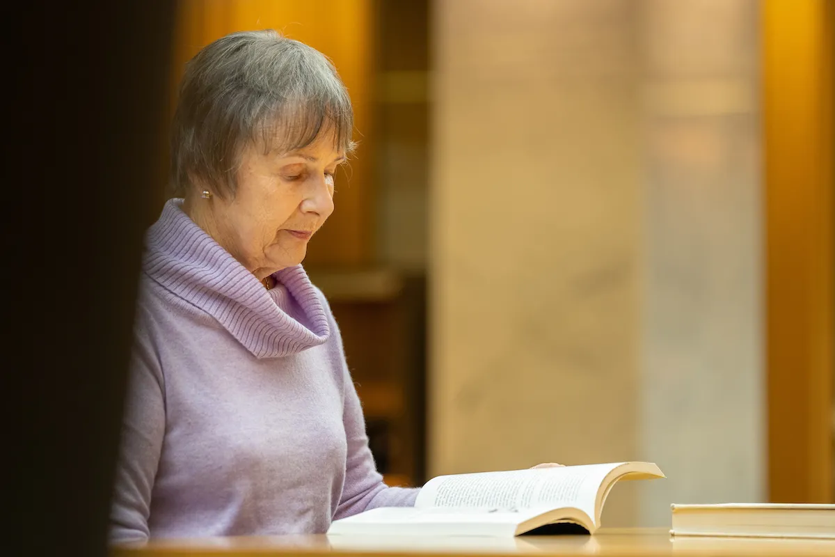 A woman reading a book at a desk