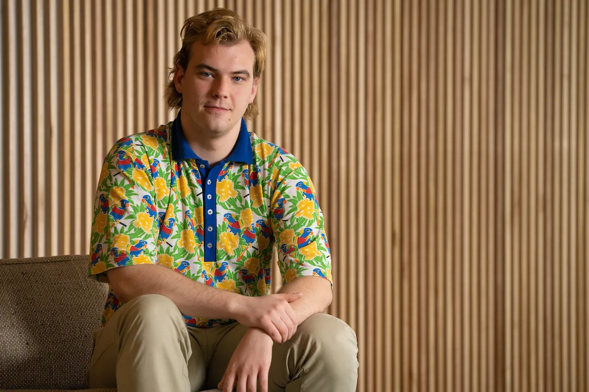 A man in a brightly coloured shirt sitting on a couch