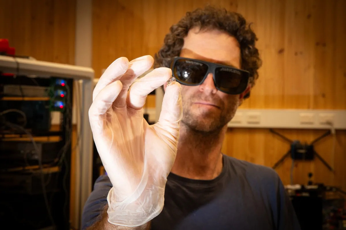 Physicist holds tiny glass cell