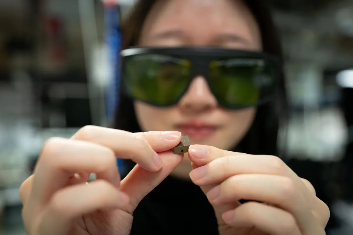 ANU Civil Engineering student, Jade Tu, analyses a small piece of the Sydney Harbour Bridge. Photo: Dave Fanner/ANU Close-up of a woman holding a bolt