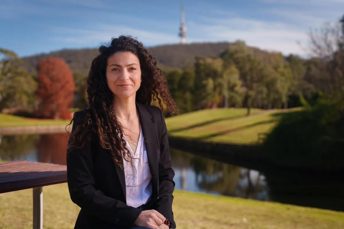 Associate Professor Ana Sequeira is photographed with a campus landscape behind her.