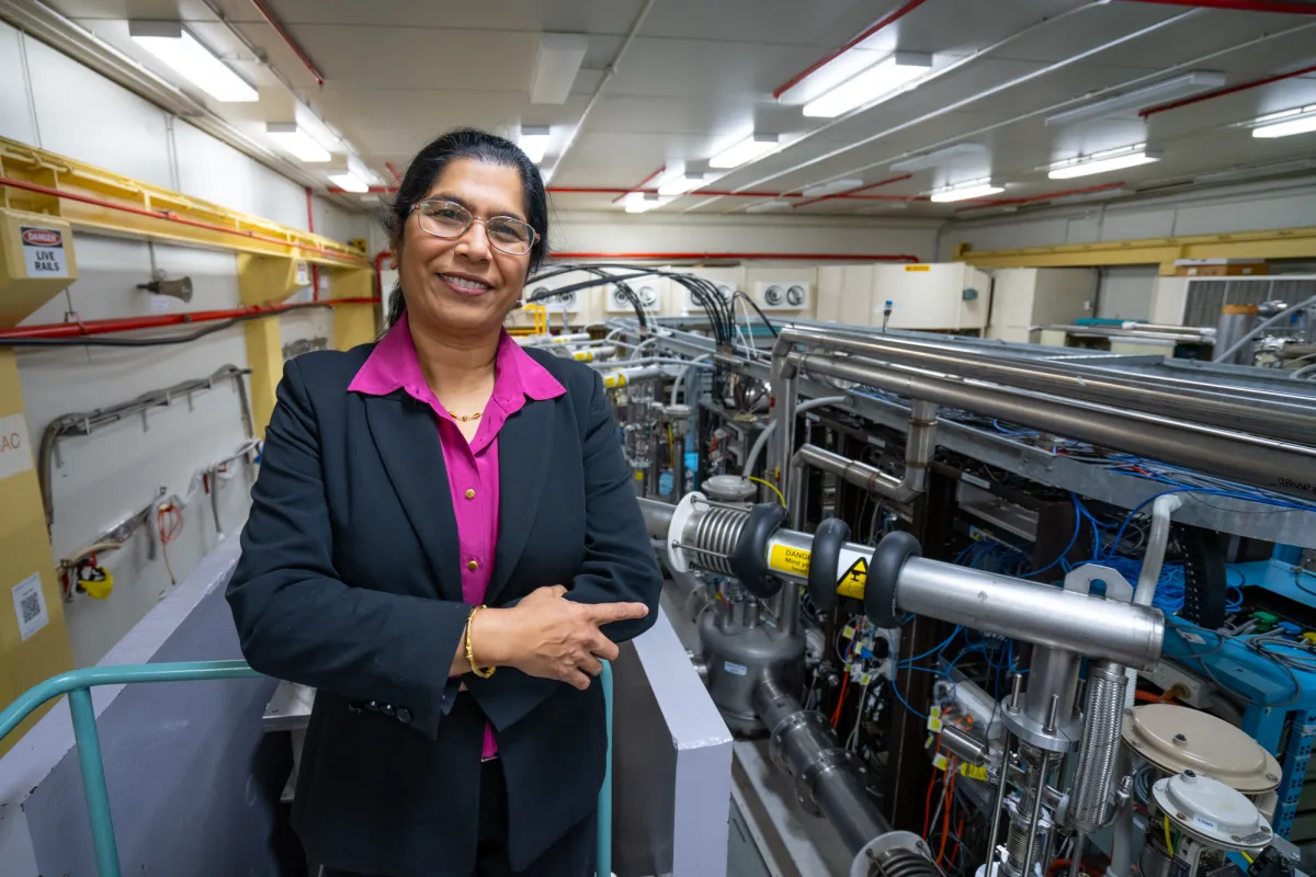 A woman standing next to pipes and wires