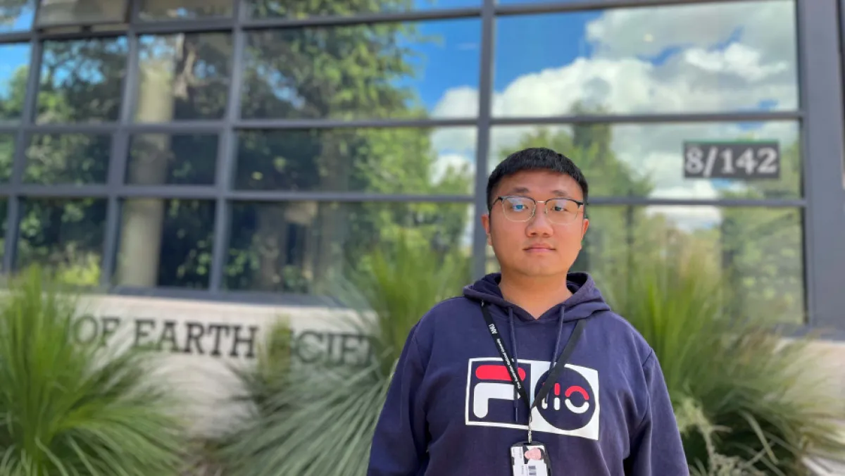 A man stand in front of a reflective building