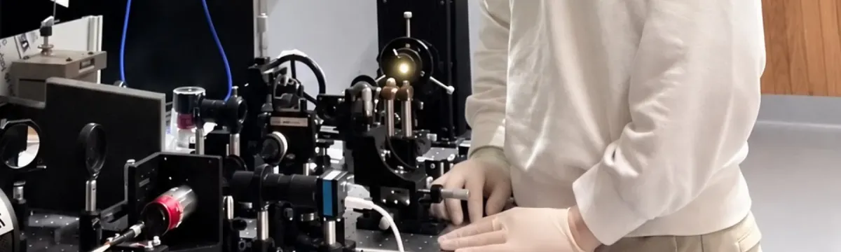 Physicist wearing eye protection standing next to a laser