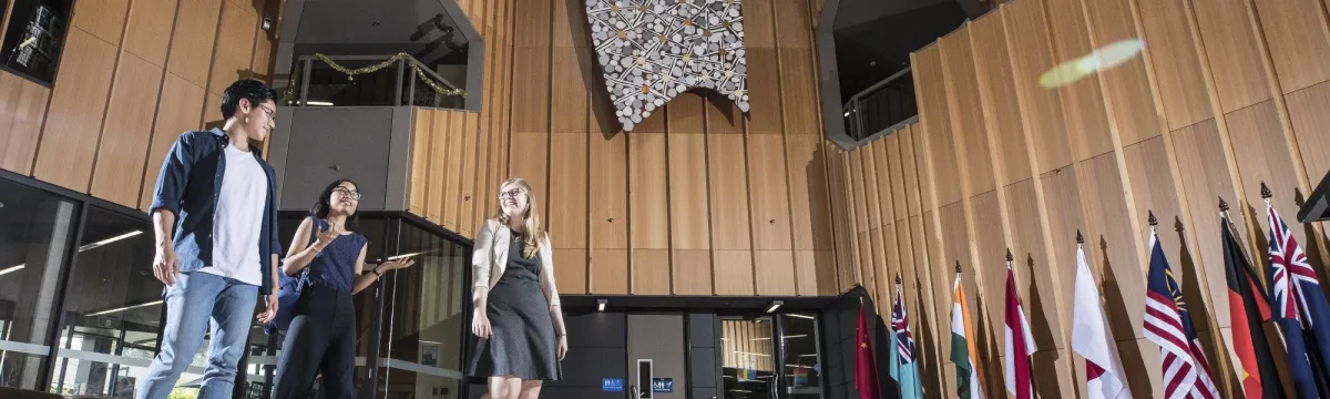 Three students walking in a hall