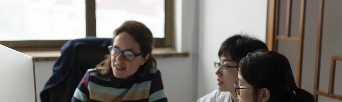 A professor and two students looking at a monitor