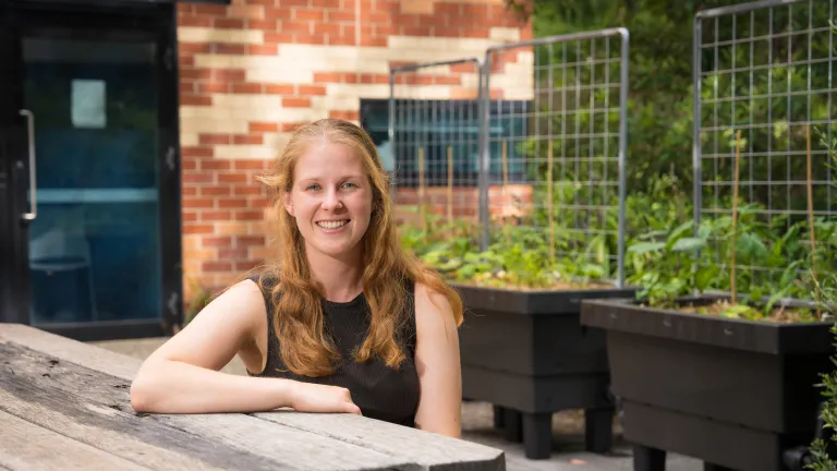A smiling woman sitting at an outdoor table