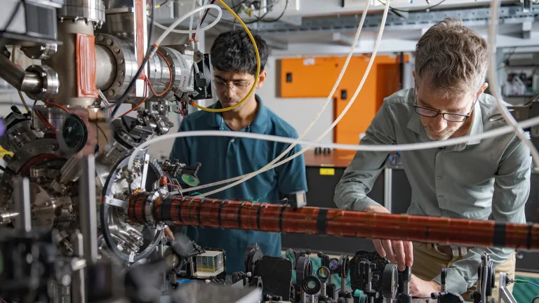 Yogesh Sridhar and Sean Hodgman are working in a physics laboratory. There are lots of cords and metal equipment