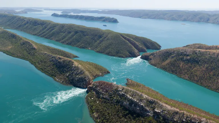 An aerial view of fast-flowing water between two narrow channels