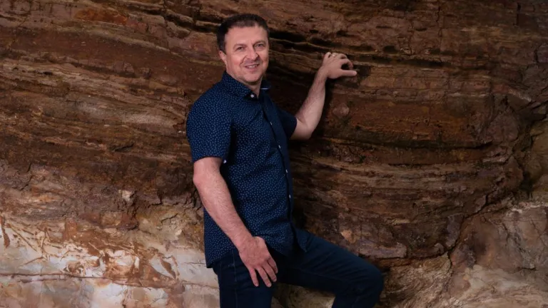 Man next to large rock