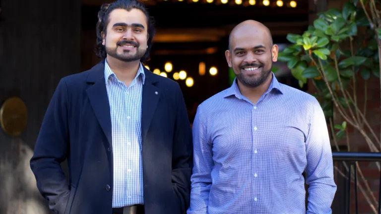 Two smiling men wearing business attire
