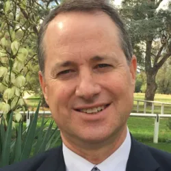 A smiling man wearing a suit