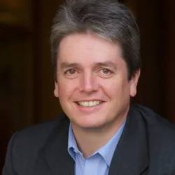 A man in a suit smiling