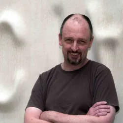 Professor Gavin Huttley A man with crossed arms smiling at the camera