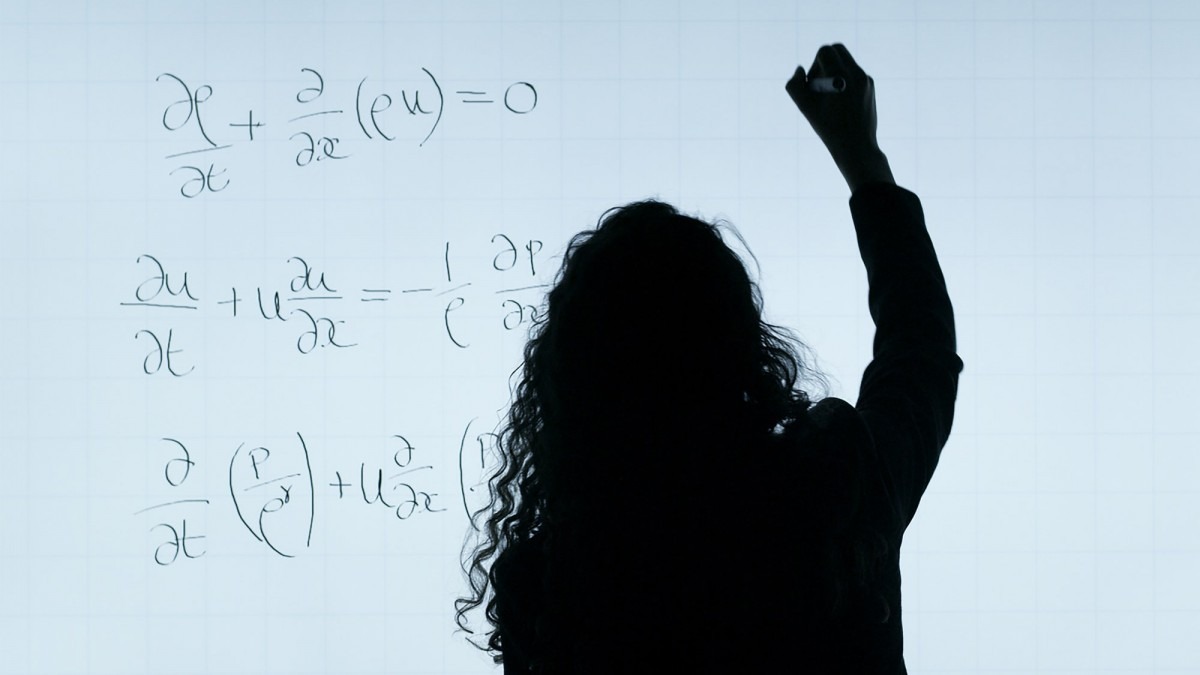 Woman writing mathematics equations