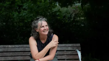Sarah Mann sits outside on a park bench.