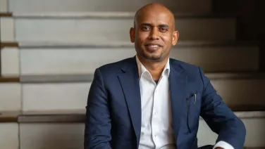 Dr Uday Yadav sits on some stairs for a portrait photo.