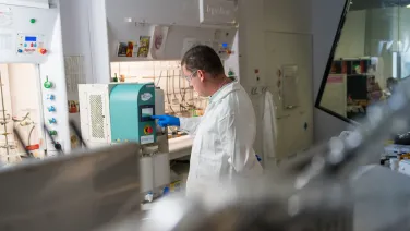 person in a chemstry lab using a solvent recycler