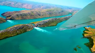 An aerial view of fast-flowing water between a narrow channel