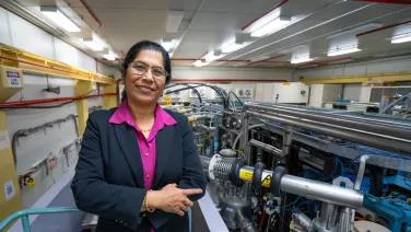 A woman standing next to pipes and wires