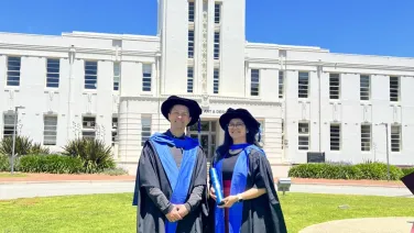Two graduands in front of a building