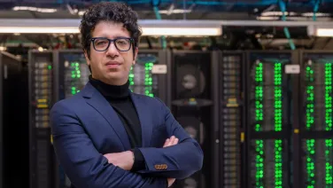 Dr Eli Niktab standing in front of computer servers