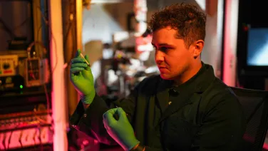 A man looks at a syringe