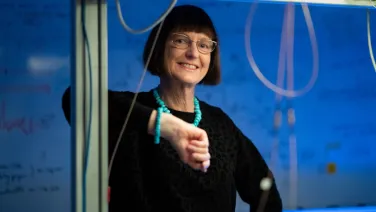 Professor Susan Scott stands facing the camera, smiling.