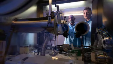 Two people looking at optical technology in a lab