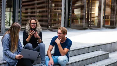 Three people sitting on the stairs