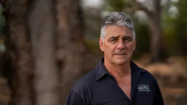 Headshot of a man in front of trees